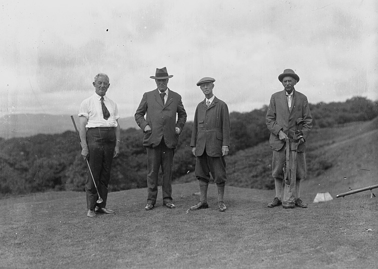 Four gentlemen golfers on the tee of a golf course
